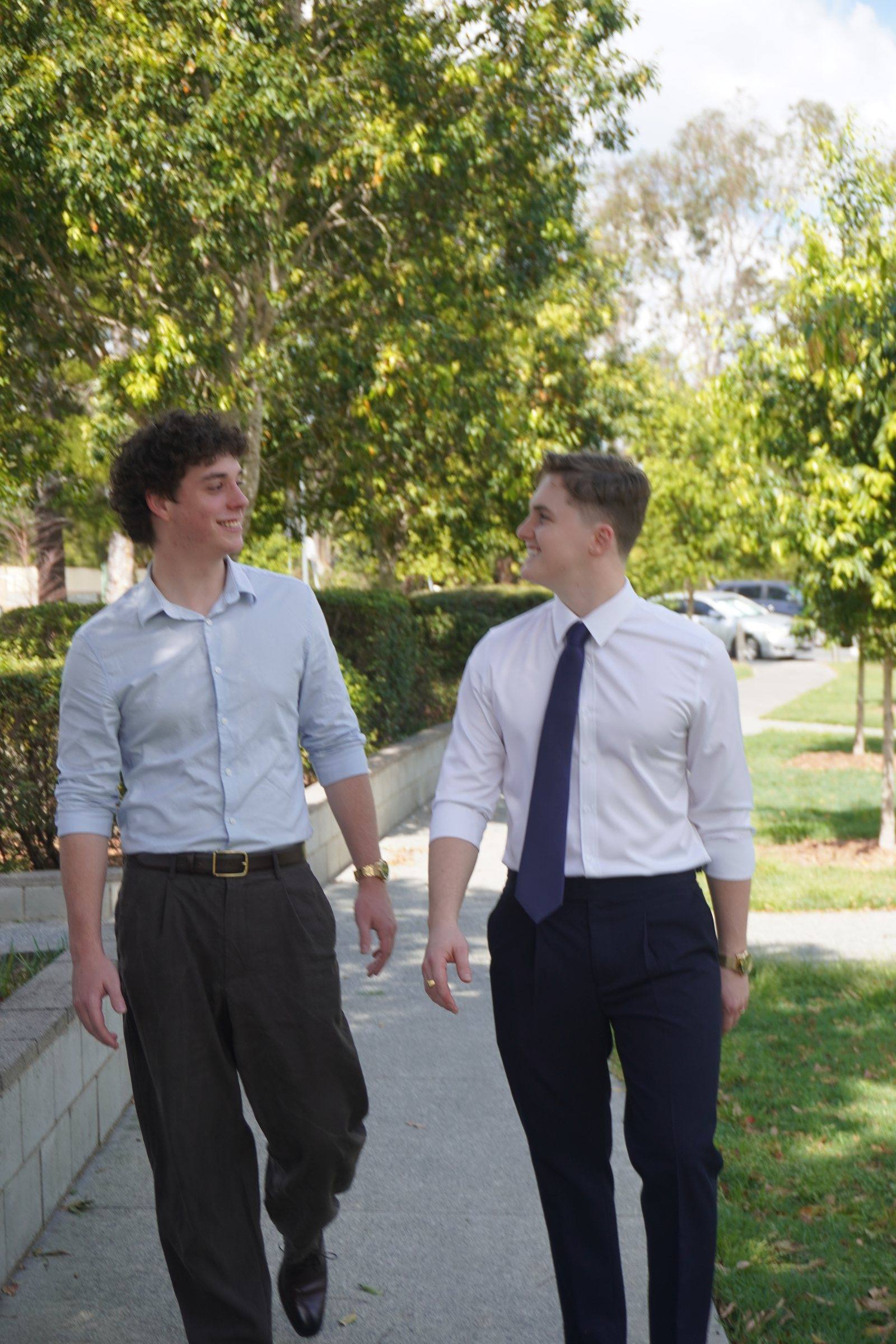 Levi and Zeek walking side by side on a footpath, laughing