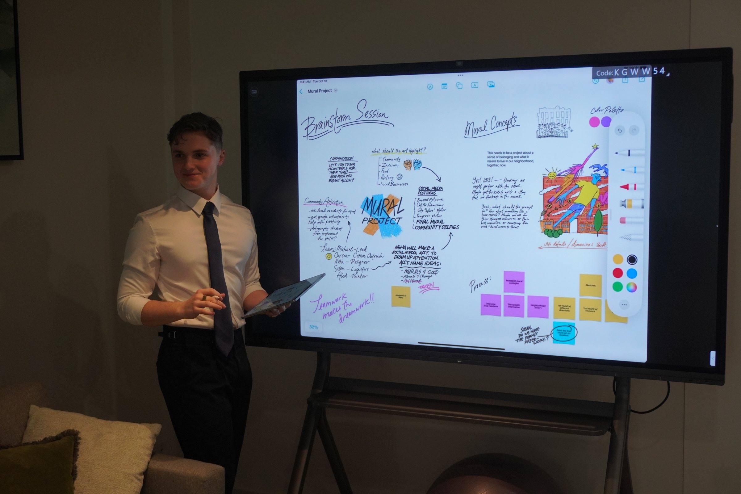 Zeek running a workshop beside a large digital whiteboard covered in notes