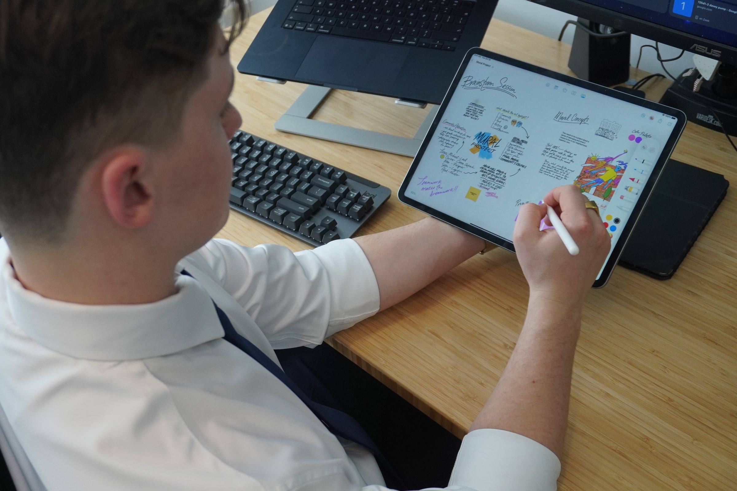 Zeek sketching a workflow on a tablet at his desk